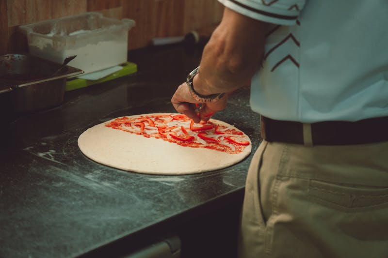 Restaurant kitchen team preparing fresh pizzas